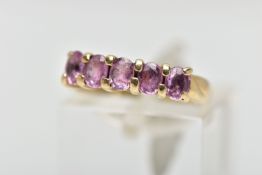 A 9CT GOLD FIVE STONE RING, designed with a row of four claw set, oval cut pink stones assessed as