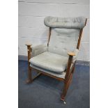 A MID CENTURY PARKER KNOLL MODEL PK 1031/4 TEAK ROCKING CHAIR (condition:-torn upholstered seat, and