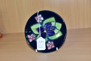 A MOORCROFT POTTERY PIN DISH DECORATED IN A VIOLET PATTERN, a second, bears silver line, painted and