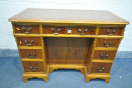 A YEW WOOD WRITING DESK, with tanned tooled leather inlay, canted corners, nine assorted drawers,