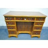 A YEW WOOD WRITING DESK, with tanned tooled leather inlay, canted corners, nine assorted drawers,