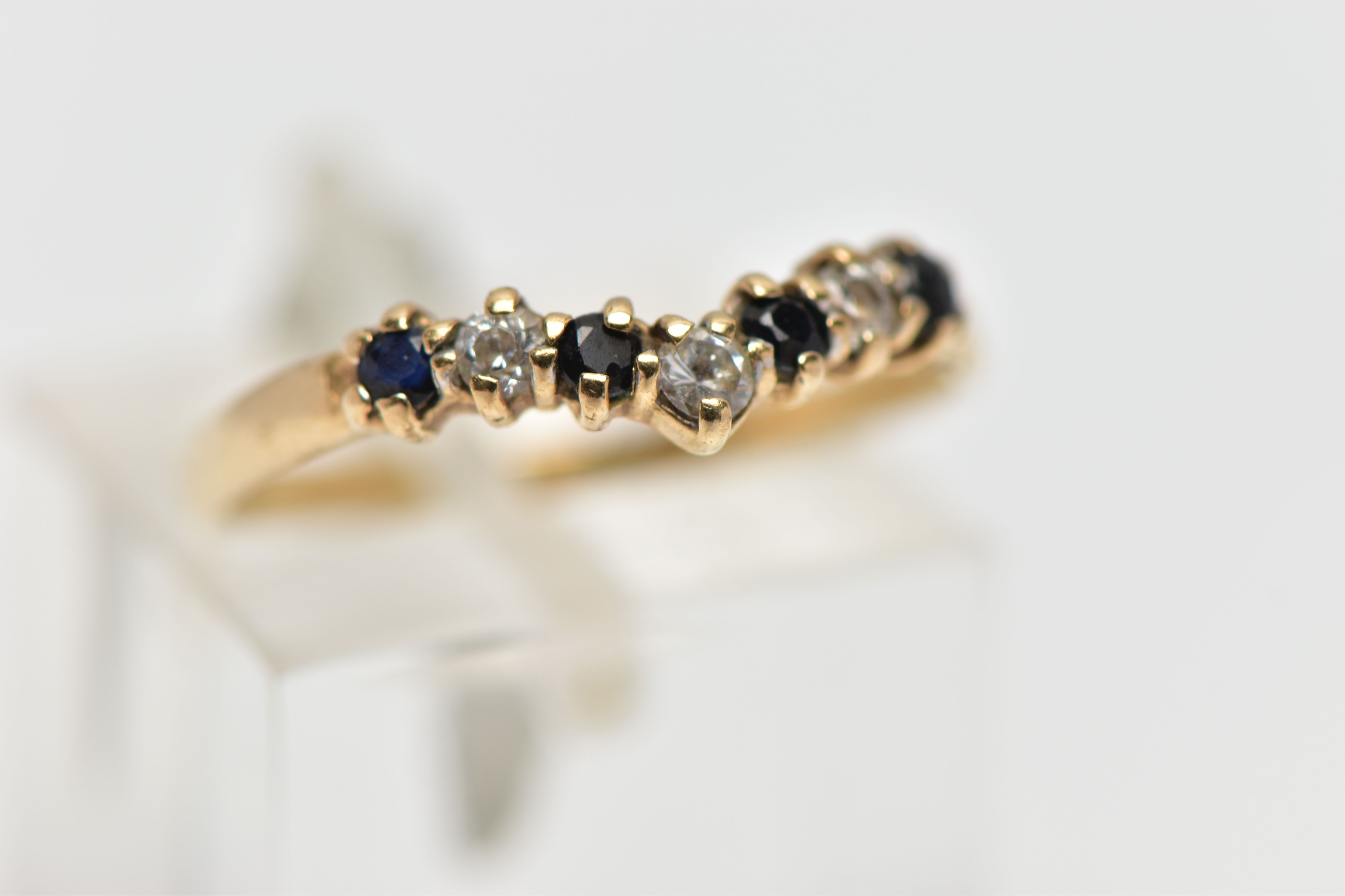 A 9CT GOLD GEM SET WISH BONE RING, designed with a row of four claw set, circular cut sapphires - Bild 4 aus 4