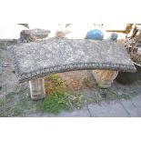 A COMPOSITE CURVED GARDEN BENCH, on twin scrolled supports, length 116cm x height 44cm