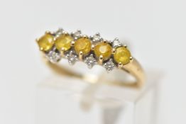 A 9CT GOLD GEM SET RING, designed with a central row of five circular cut yellow stones assessed