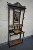 AN EDWARDIAN OAK HALL STAND, with six hooks flanking a bevelled mirror, width 76cm x depth 28cm x