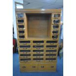 A MID-CENTURY BEECH HABERDASHERY CABINET, made up of two banks of five glass front drawers that's