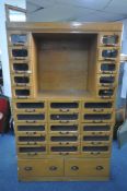 A MID-CENTURY BEECH HABERDASHERY CABINET, made up of two banks of five glass front drawers that's