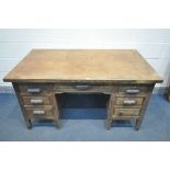 A 1940'S OAK DESK, with six assorted drawers, with later fitted Bakelite handles, width 143cm x