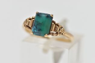 A YELLOW METAL TURQUOISE RING, rectangular blue/green turquoise cabochon, four claw set in a