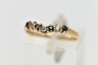 A 9CT GOLD GEM SET WISH BONE RING, designed with a row of four claw set, circular cut sapphires