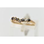 A 9CT GOLD GEM SET WISH BONE RING, designed with a row of four claw set, circular cut sapphires