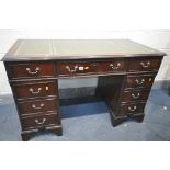 A MAHOGANY PEDESTAL DESK, with a green leather writing surface and an arrangement of nine drawers,