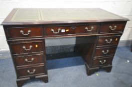 A MAHOGANY PEDESTAL DESK, with a green leather writing surface and an arrangement of nine drawers,