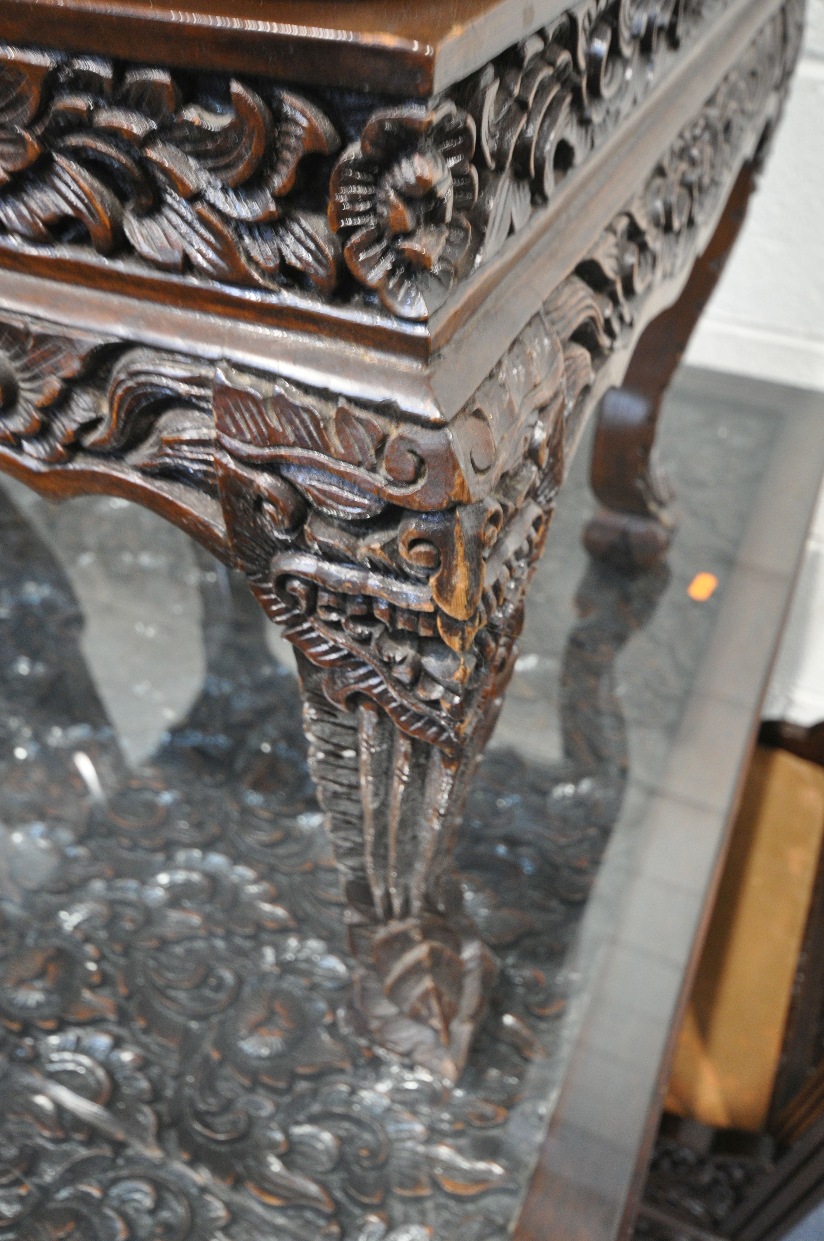 A 20TH CENTURY THAI ORIENTAL HEAVILY CARVED STAINED TEAK DINING TABLE, the recessed top with a - Image 6 of 7