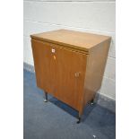A MID CENTURY TEAK SEWING CABINET. with a fold over top and single door, enclosing a rise and fall