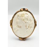 A YELLOW METAL LAVA CAMEO BROOCH, the cameo carved to depict a lady in profile with floral detail to