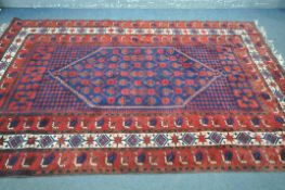 A 20TH CENTURY PERSIAN SHIRAZ RUG, with a blue and red field, 307cm x 189cm (condition:-missing some