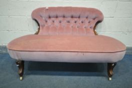 A VICTORIAN SOFA, with a shaped button back, and covered in pink upholstery, on shaped front legs,