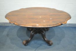 A VICTORIAN ROSEWOOD BREAKFAST TABLE, the wavy tilt top on bulbous upright, on four scrolled legs,