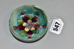 A MOORCROFT POTTERY COLUMBINE FOOTED BOWL, with a tube lined purple and yellow columbine flower on a