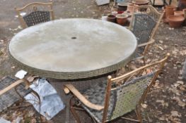 A MODERN STELL FRAMED AND RATTAN WRAPPED GARDEN TABLE with glass top and four similar chairs , table