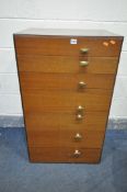 A MID CENTURY MEREDEW TEAK AND WALNUT CHEST OF SEVEN DRAWERS, with off centre brass handles, width