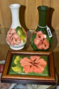THREE PIECES OF MOORCROFT POTTERY, comprising two coral hibiscus bud vases, one having a cream