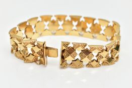 A YELLOW METAL FANCY LINK BRACELET, a wide bracelet made up of star shape links with floral