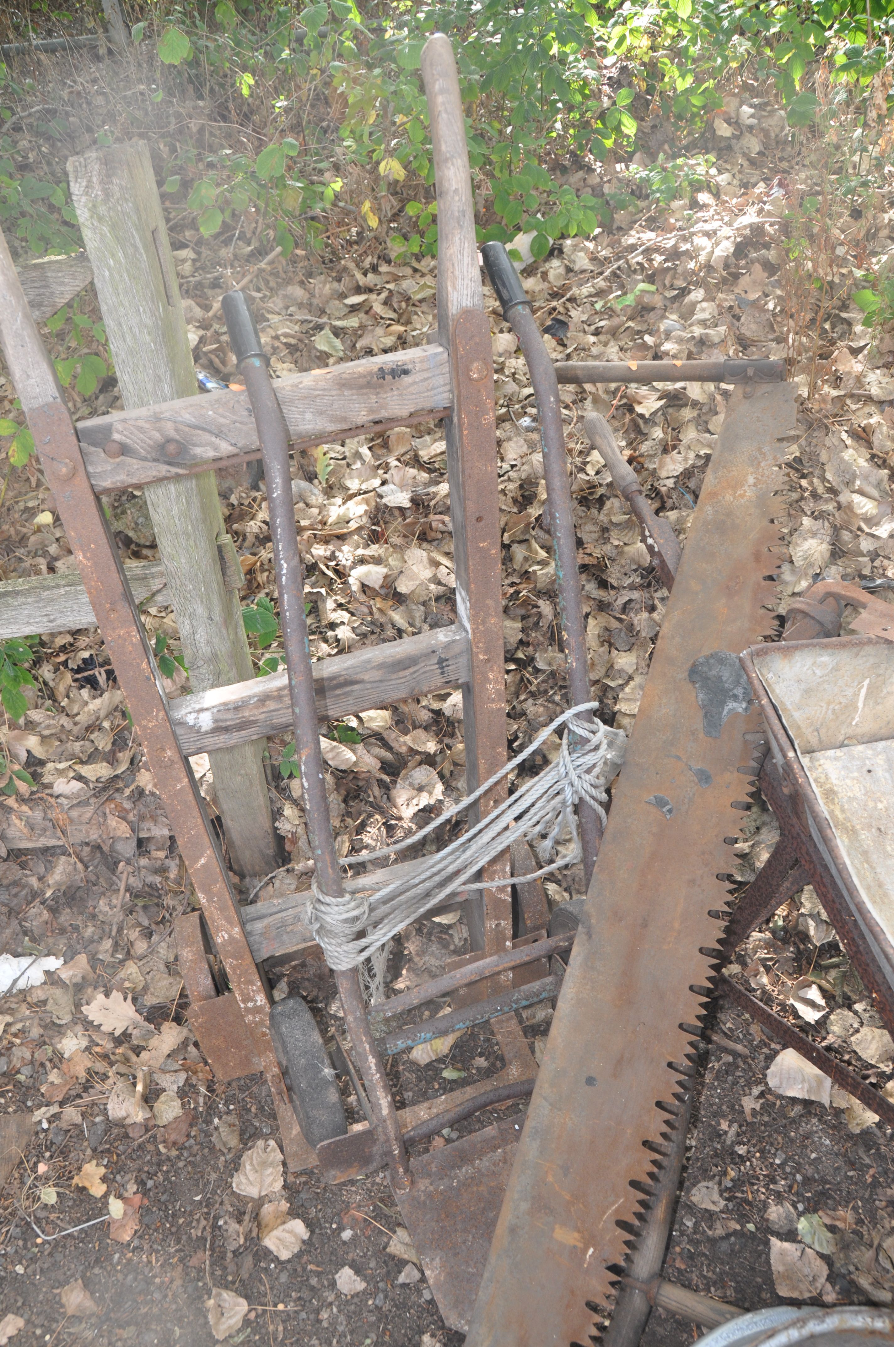 A SEVERLY WEATHERED VINTAGE WOODEN BEAM, a builders wheel barrow, two vintage sack trucks, a vintage - Image 3 of 4