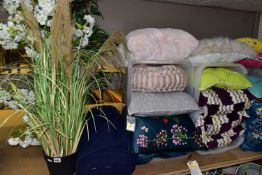 A GROUP OF NEW AND UNUSED CUSHIONS, BOLSTERS, ARTIFICIAL PLANTS AND A LARGE BALE OF NAVY BLUE