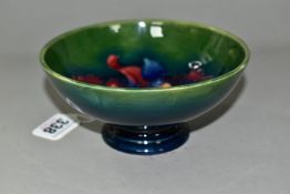 A MOORCROFT POTTERY FOOTED BOWL, in Orchid pattern, with tube lined red and navy orchids on a blue