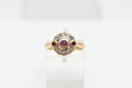 A 14CT GOLD RUBY AND DIAMOND RING, designed with a central circular cut ruby collet set, flanked