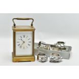 A BRASS CARRIAGE CLOCK AND NAPKIN RINGS, brass carriage clock with glass viewing panels, unsigned