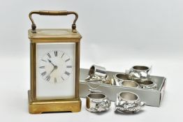 A BRASS CARRIAGE CLOCK AND NAPKIN RINGS, brass carriage clock with glass viewing panels, unsigned