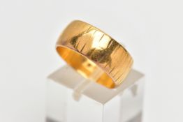 A 22CT GOLD WEDDING BAND, designed as a plain polished band with engraved line detail, approximate