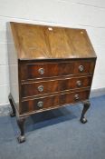 A MAHOGANY BUREAU, enclosing a fitted interior, above four drawers, cabriole legs and ball and