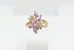 A YELLOW METAL CUBIC ZIRCONIA RING, designed as two colourless cubic zirconia set flowers detailed
