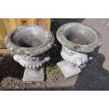 A PAIR OF MODERN COMPOSITE GARDEN URNS one piece in construction with dual mask motifs on opposing