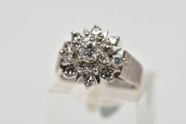 A WHITE METAL DIAMOND FLORAL CLUSTER RING, comprising a brilliant cut central diamond with single