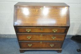 A GEORGIAN OAK AND MAHOGANY CROSS BANDED FALL FRONT BUREAU, with fitted interior, above three