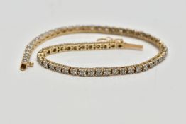 A 9CT YELLOW GOLD DIAMOND LINE BRACELET, designed as a series of approximately sixty two uniform