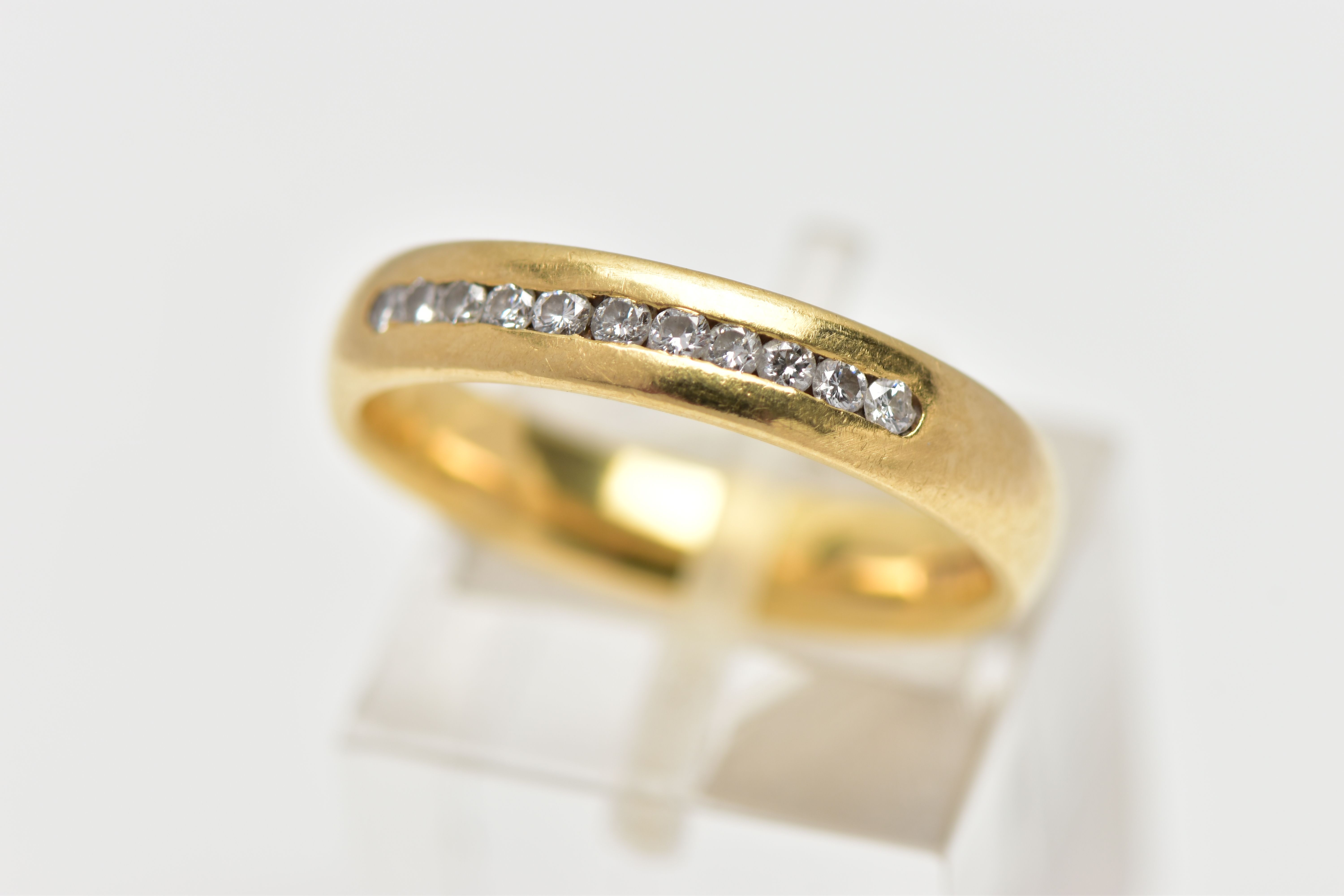 AN 18CT YELLOW GOLD DIAMOND BAND RING, set with a line of eleven round brilliant cut diamonds,