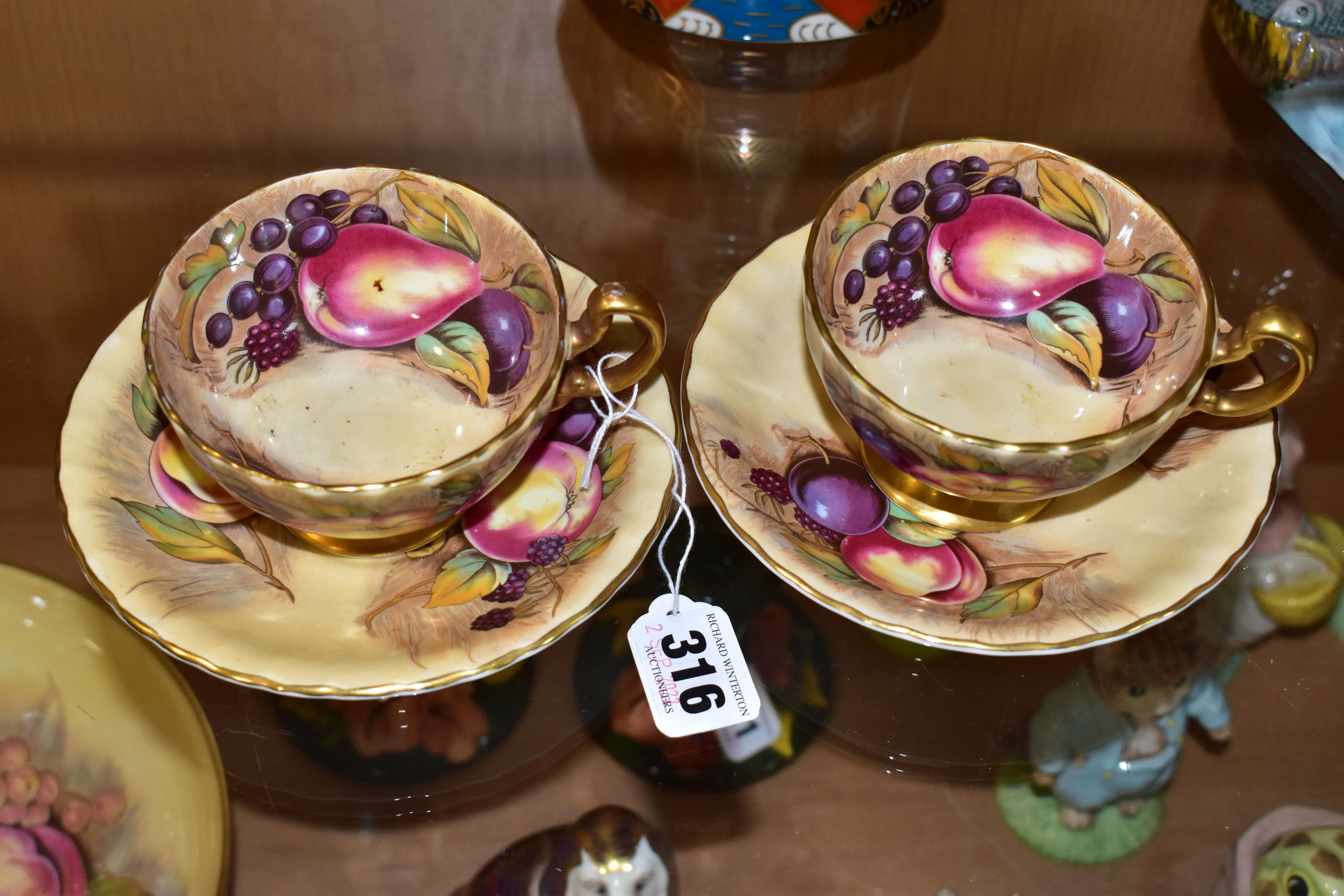 A PAIR OF AYNSLEY ORCHARD GOLD TEA CUPS AND SAUCERS, with gilt handles and rims, printed with