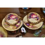 A PAIR OF AYNSLEY ORCHARD GOLD TEA CUPS AND SAUCERS, with gilt handles and rims, printed with