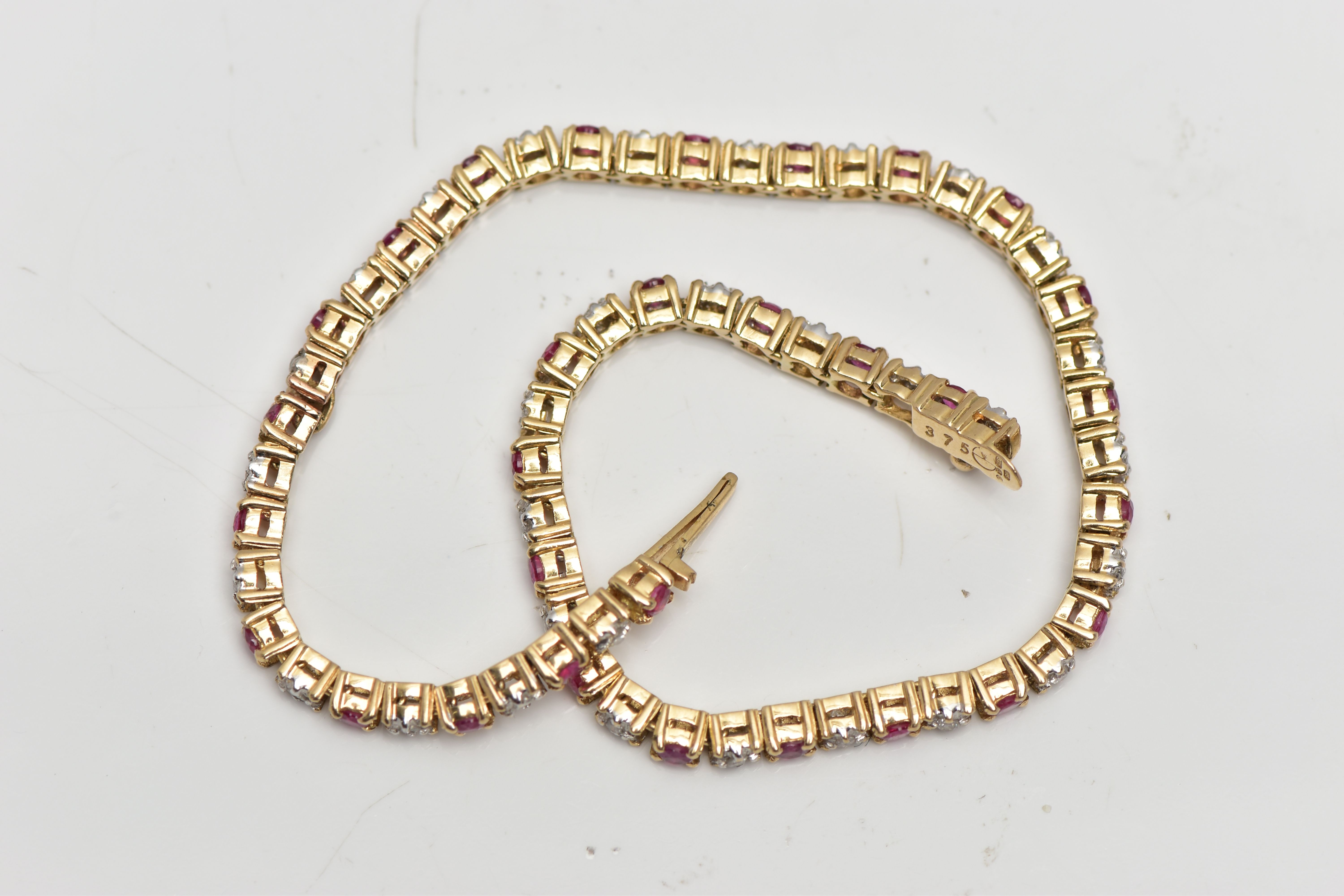 A 9CT YELLOW GOLD DIAMOND AND RUBY LINE BRACELET, set with approximately thirty one round - Image 2 of 3