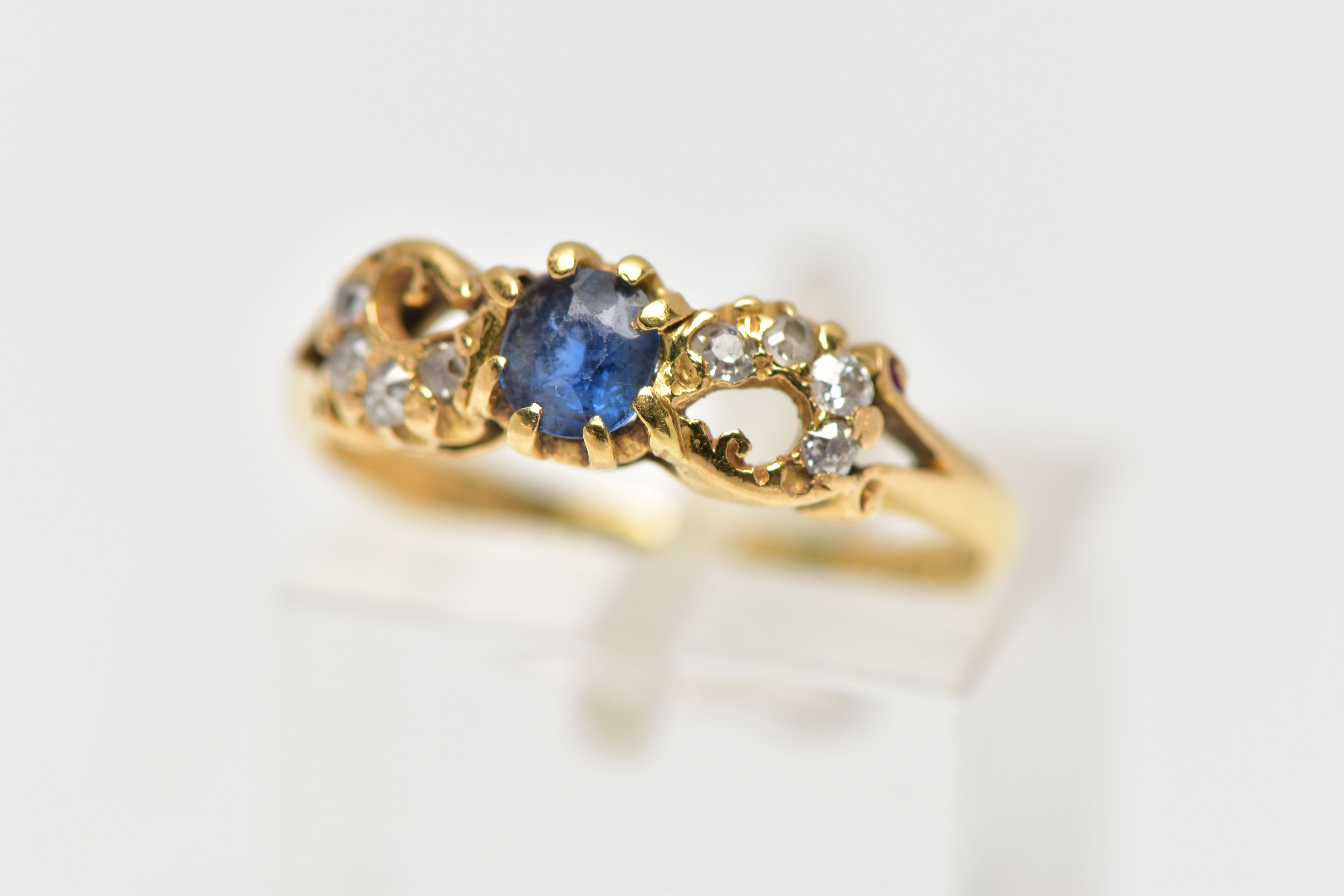 A LATE VICTORIAN 18CT GOLD SAPPHIRE AND DIAMOND DRESS RING, the oval cut sapphire claw set, with old