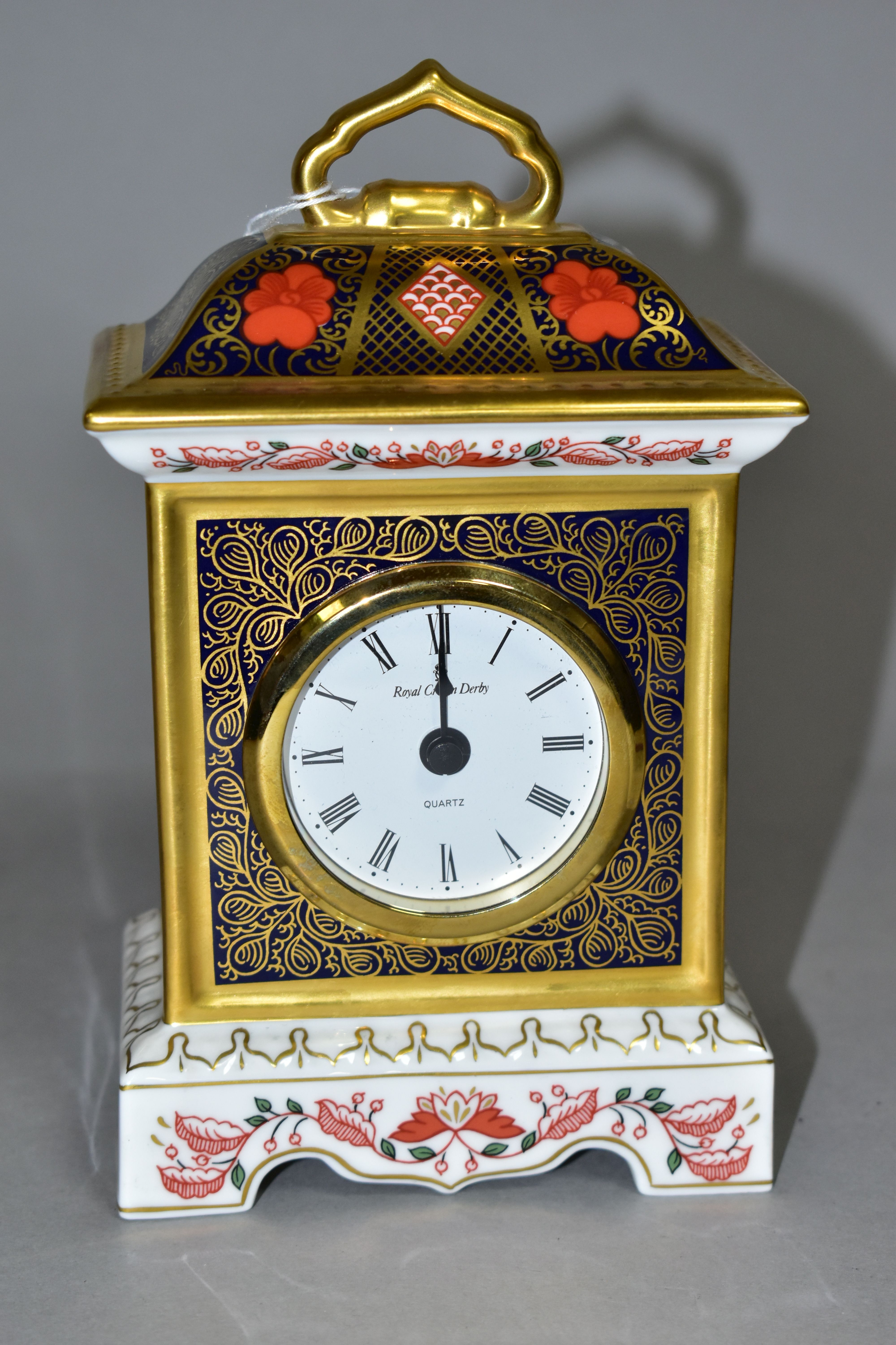 A ROYAL CROWN DERBY OLD IMARI 1128 SOLID GOLD BAND MANTEL CLOCK, with quartz movement, having red