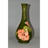 A LARGE MOORCROFT POTTERY BOTTLE VASE, in the coral 'Hibiscus' pattern on a green ground, height