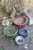 SIX GLAZED GARDEN PLANTERS the largest being red glazed, planted with foliage 40cm in diameter