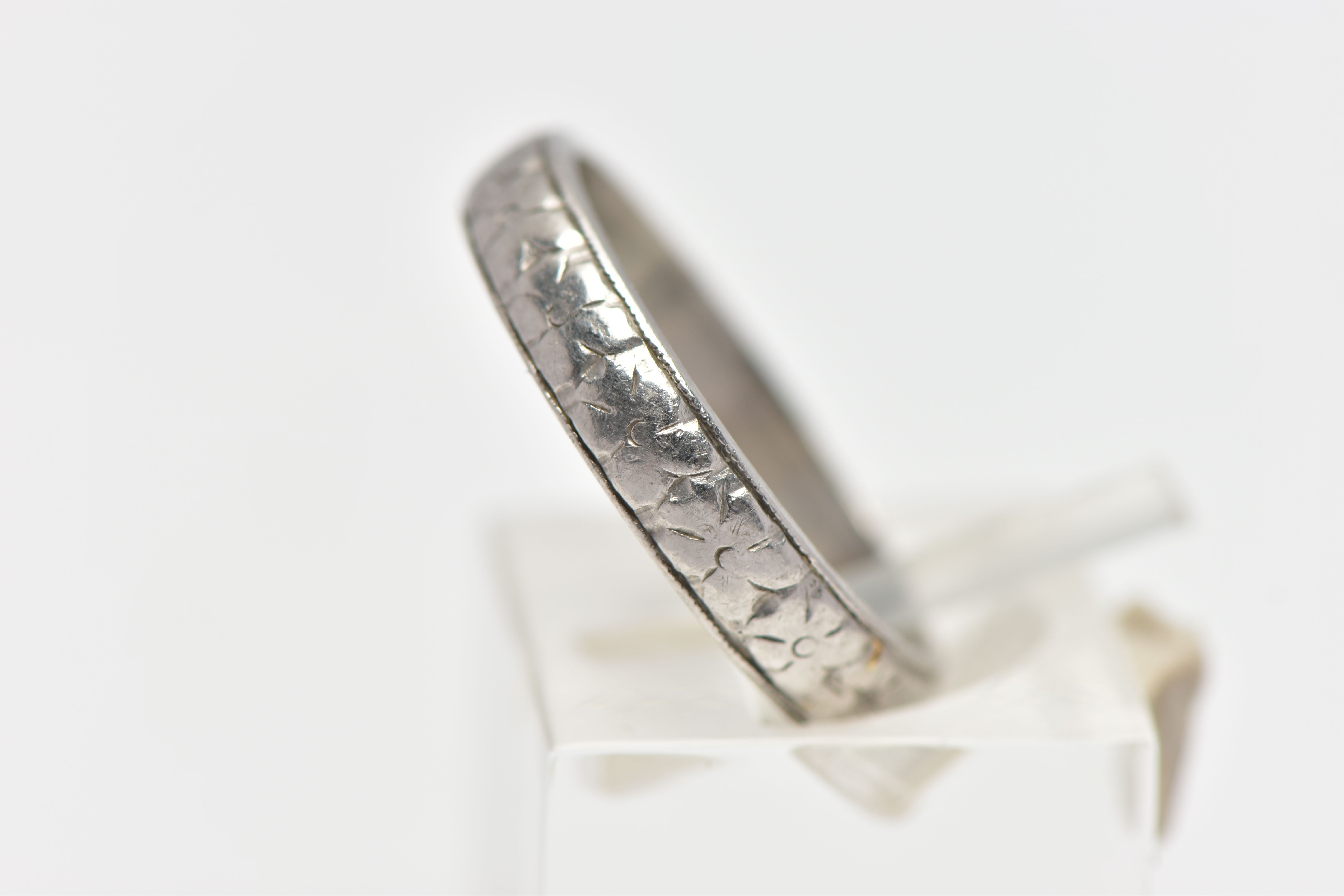 A WHITE METAL BAND RING, decorated with a slightly worn floral pattern, stamped 'HA Platinum', - Image 2 of 4